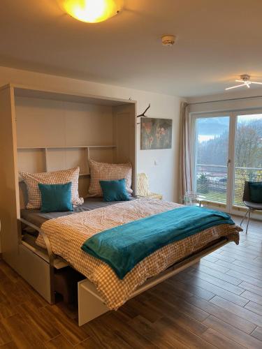 a bedroom with a large bed with a large window at FeWo Gretchen in Berchtesgaden