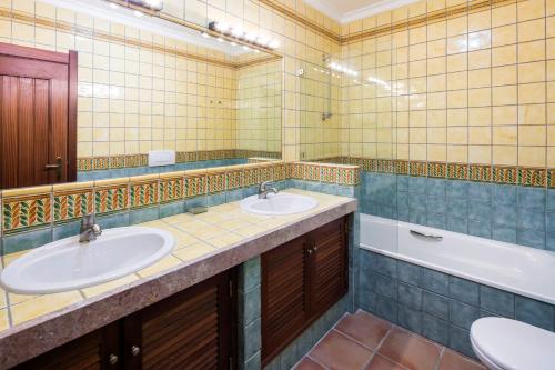 ein Badezimmer mit zwei Waschbecken und einer Badewanne in der Unterkunft Casa Pedrinho (Terraços de Benagil 41) in Benagil