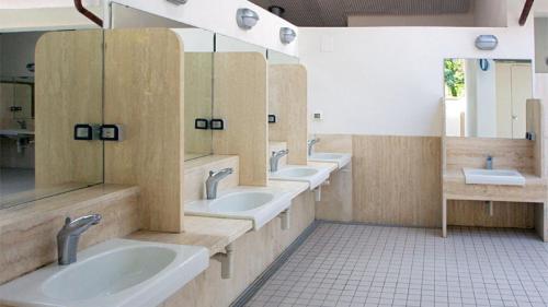 a bathroom with three sinks and a row of mirrors at GoOutside Toscana in Sarteano