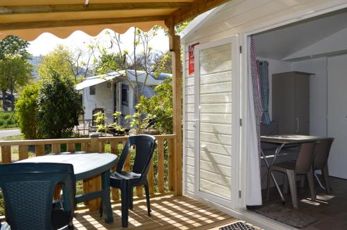 un patio avec une table et des chaises sur une terrasse dans l'établissement Camping Les Trois Chateaux, à Eguisheim