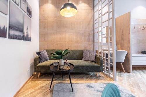 - un salon avec un canapé vert et une table dans l'établissement ZEUS Design Apartments, à Vienne