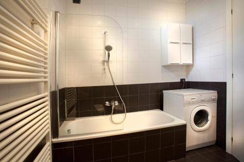uma casa de banho com uma banheira e uma máquina de lavar roupa em FILARMONICO SUITES em Verona