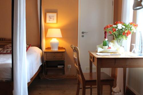 a bedroom with a table with a vase of flowers on it at Hotel Theophano in Quedlinburg