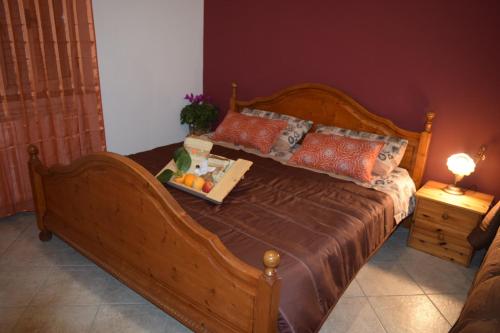 a wooden bed with a tray of fruit on it at Nonna Sicilia B&B in Capri Leone