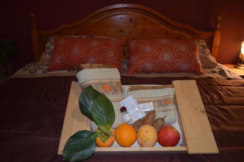 a tray of fruit on a bed with a tray of apples and oranges at Nonna Sicilia B&B in Capri Leone