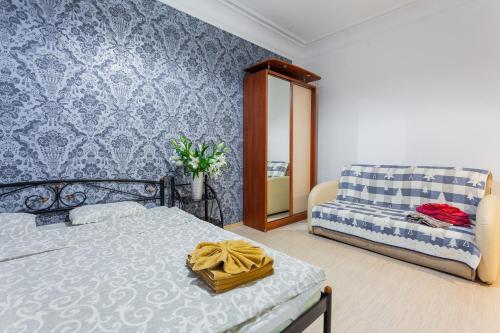 ein Schlafzimmer mit einem Bett, einem Sofa und einem Spiegel in der Unterkunft Tarasa Shevchenko Boulevard 10 in Kiew
