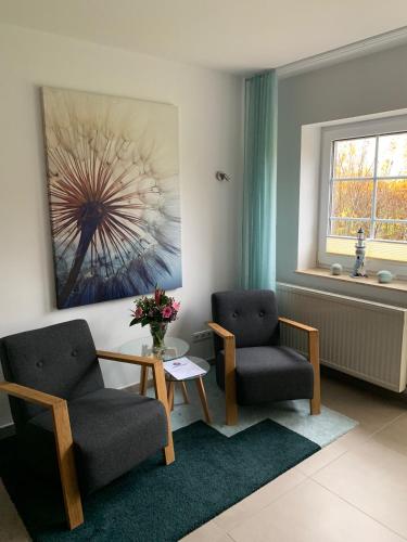 a living room with two chairs and a table at Appartementanlage Lancken-Granitz in Lancken-Granitz