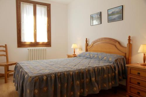 Un dormitorio con una cama con una manta azul. en La Coma De Alba, en Benasque
