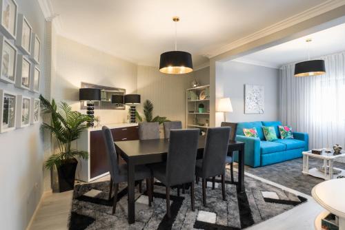 a dining room with a table and a blue couch at Metropolitan Gaia-Porto in Vila Nova de Gaia