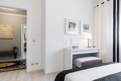a white bedroom with a bed and a table at Metropolitan Gaia-Porto in Vila Nova de Gaia