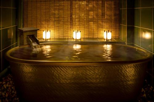 bañera grande con velas en una habitación en THE JUNEI HOTEL Kyoto Imperial Palace West en Kyoto