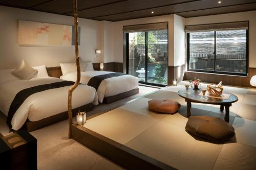 THE JUNEI HOTEL Kyoto Imperial Palace West في كيوتو: غرفة نوم كبيرة بسريرين وطاولة