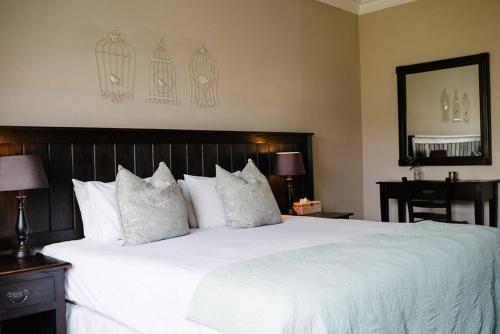 a bedroom with a large bed with white sheets and pillows at African Sands B&B in Amanzimtoti