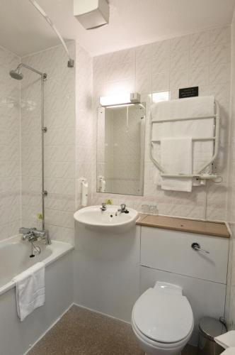 a bathroom with a sink and a toilet and a bath tub at The Mount by Greene King Inns in Wigan