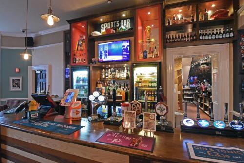 a bar in a pub with a lot of alcohol at The Mount by Greene King Inns in Wigan