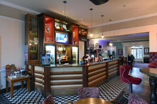 bar w restauracji ze stołami i krzesłami w obiekcie The Mount by Greene King Inns w mieście Wigan