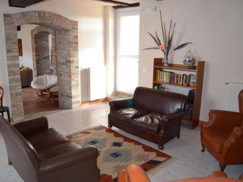 sala de estar con 2 sillas de cuero y chimenea en La Locanda, en Calvignano