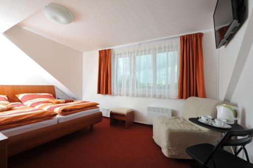 a bedroom with a bed and a chair and a window at Habitat 16 in Prague