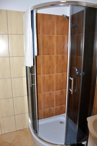 a shower with a glass door in a bathroom at Maciejowa Chata in Pobiedziska
