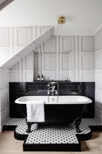 a bath tub in a bathroom with a staircase at Pembroke Townhouse in Dublin