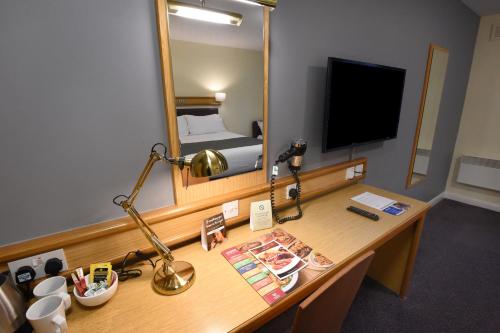 a room with a desk with a mirror and a bed at The Mount by Greene King Inns in Wigan