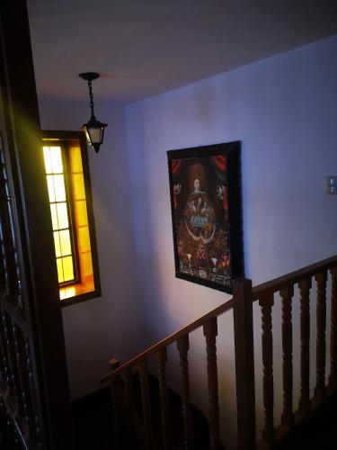 a painting on a wall next to a staircase with a window at Inka Tambo Hacienda in Cusco