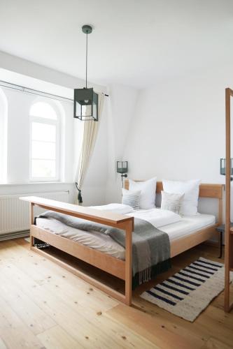 a bedroom with a large bed with a wooden frame at Gut Boltenhof in Fürstenberg-Havel