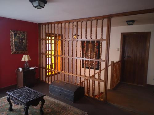 a living room with red walls and a staircase with a window at Inka Tambo Hacienda in Cusco