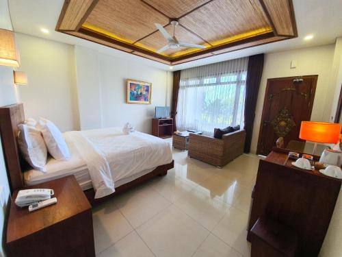 a bedroom with a bed and a desk and a ceiling at Hotel Genggong in Candidasa