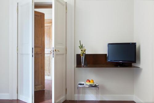 un salon avec une télévision et une table avec des fruits dans l'établissement MyNavona, à Rome