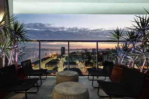 a balcony with chairs and a view of a city at Intercity Rio de Janeiro Porto Maravilha in Rio de Janeiro