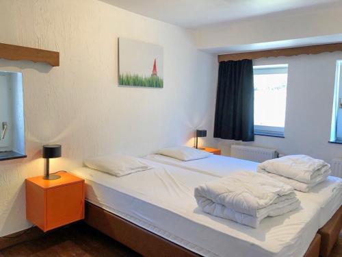 1 dormitorio con 2 camas y ventana en Moulin de Nawes, en Herbeumont