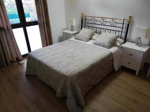 1 dormitorio con 1 cama con 2 almohadas en Puente viejo de Buitrago casa Enebro, en Buitrago del Lozoya