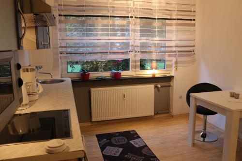 una cucina con tavolo e una finestra con persiane di Appartment in Walldorf mit Schlafzimmer, Küche und Bad a Walldorf