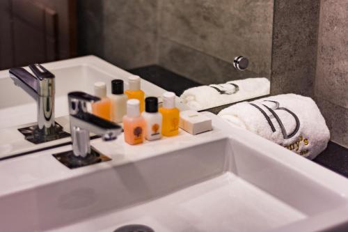 een wastafel in de badkamer met flessen zeep en handdoeken bij Bony's Holiday Inn Negombo in Negombo