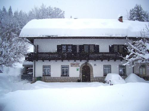 a house is covered in snow with snow at Accommodation Resman in Bohinj