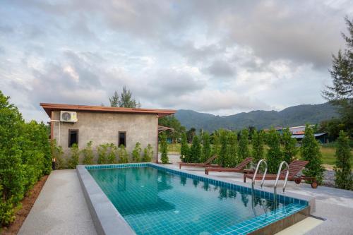 una piscina frente a una casa en Malinee Resort en Bang Tao Beach