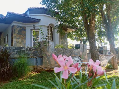 a house with pink flowers in front of it at บ้านนกเคียงจัน ปากช่อง Nok Kiang Chan Home Pak Chong in Ban Nong Ka Cha