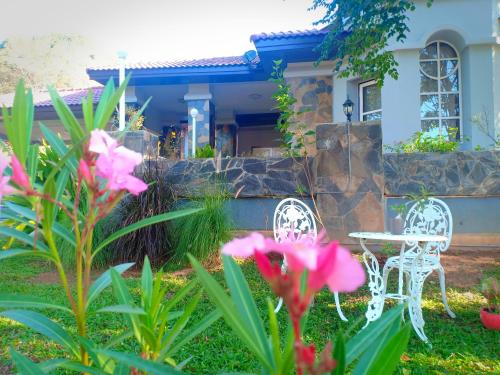 two chairs and a table in front of a house at บ้านนกเคียงจัน ปากช่อง Nok Kiang Chan Home Pak Chong in Ban Nong Ka Cha