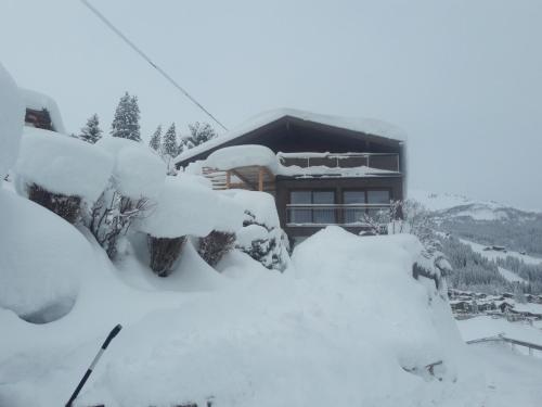 a house covered in snow in front of it at Berghäusl in Tux