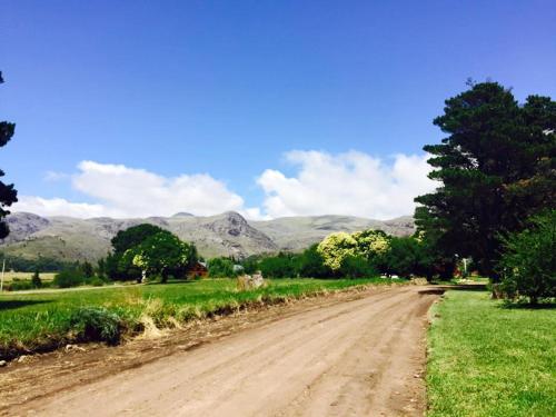 un camino de tierra con montañas en el fondo en La Posada en Villa Ventana