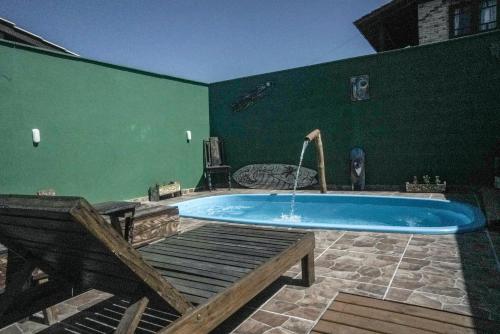una gran piscina con una pared verde en Morada da Hortensia en Guarda do Embaú