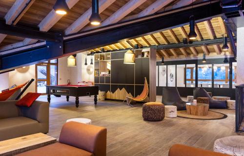 a room with a ping pong table and a pool table at Hotel Base Camp Lodge - Bourg Saint Maurice in Bourg-Saint-Maurice