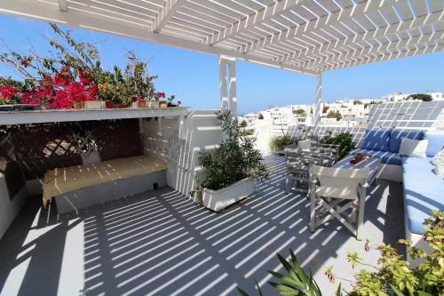 a patio with a bench and a table and chairs at Lydia's Charming House in Naoussa in Naousa