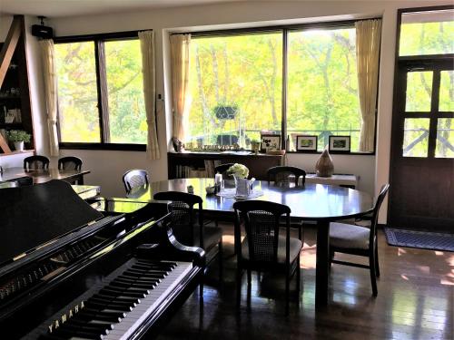 a dining room with a table and a piano at Guesthouse Kreutzer in Chino