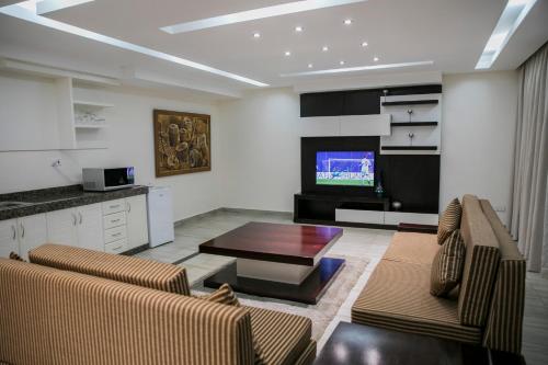 a living room with two couches and a tv at Twangale Resort & Spa in Lusaka