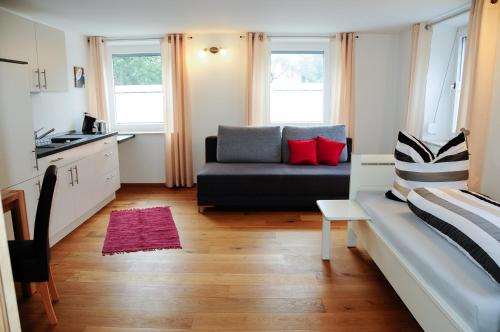 a living room with a couch and a kitchen at Allgäuer Appartements in Lachen