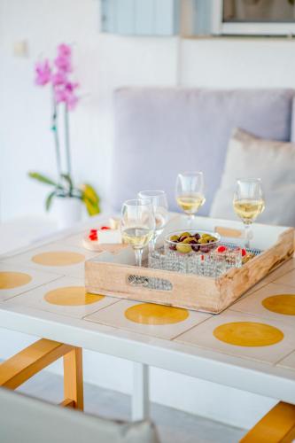 a table with wine glasses and a tray of food at Agnandi Cielo in Tourlos