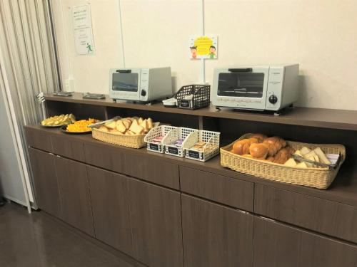 a buffet line with baskets of bread and other foods at Hotel 1-2-3 Kokura in Kitakyushu