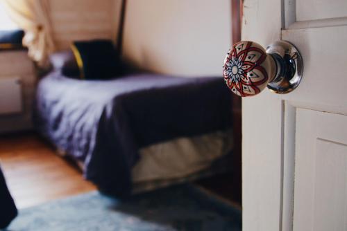 a bedroom with a bed and a door with a knob at Glatigny Farmhouse - close to beach - proche de la plage in Glatigny